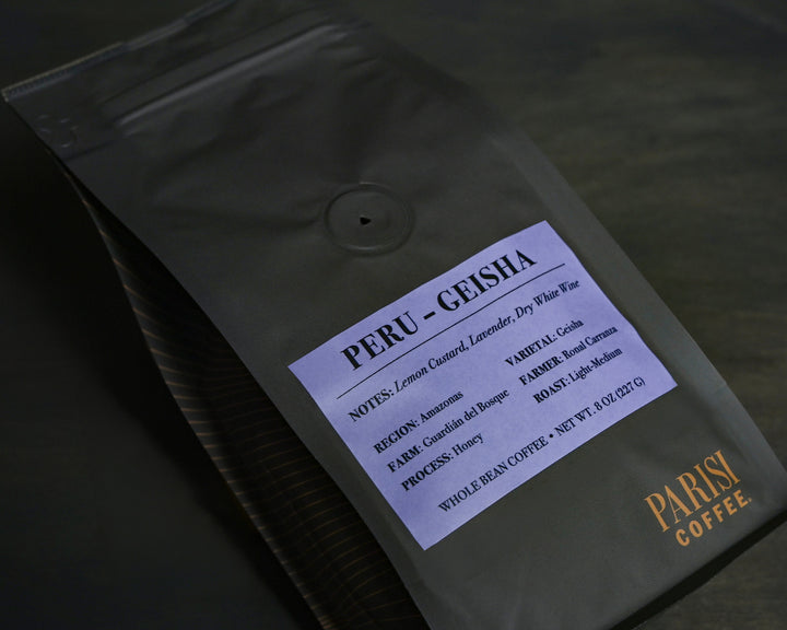 Parisi Peru Geisha honey processed coffee beans in black reserve packaging with floral and citrus tasting notes